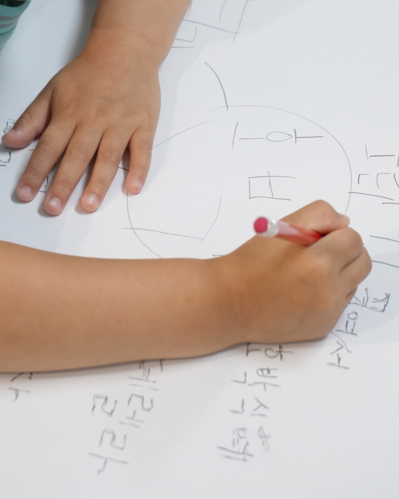 몰입지도에 연필로 생각을 적어 나가는 아이의 손